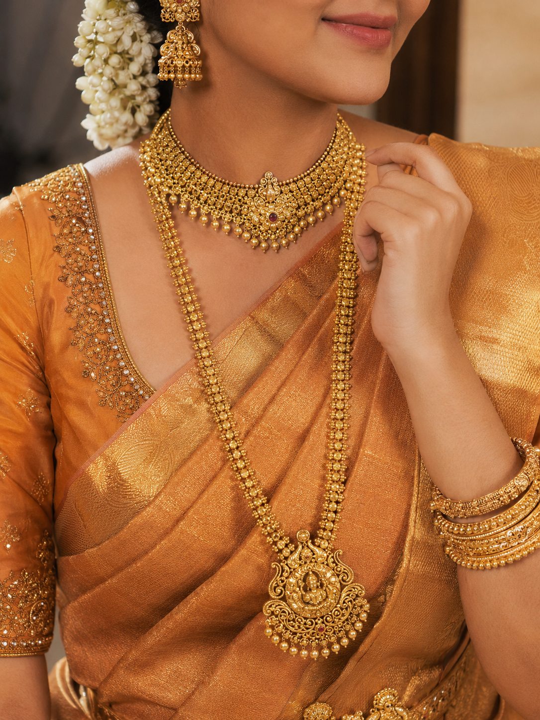 Bride in a gold silk saree wearing a gold choker and long haaram