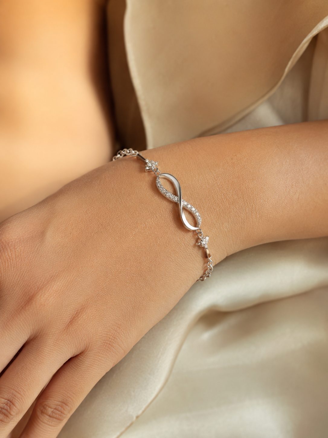 Silver infinity bracelet worn on the wrist